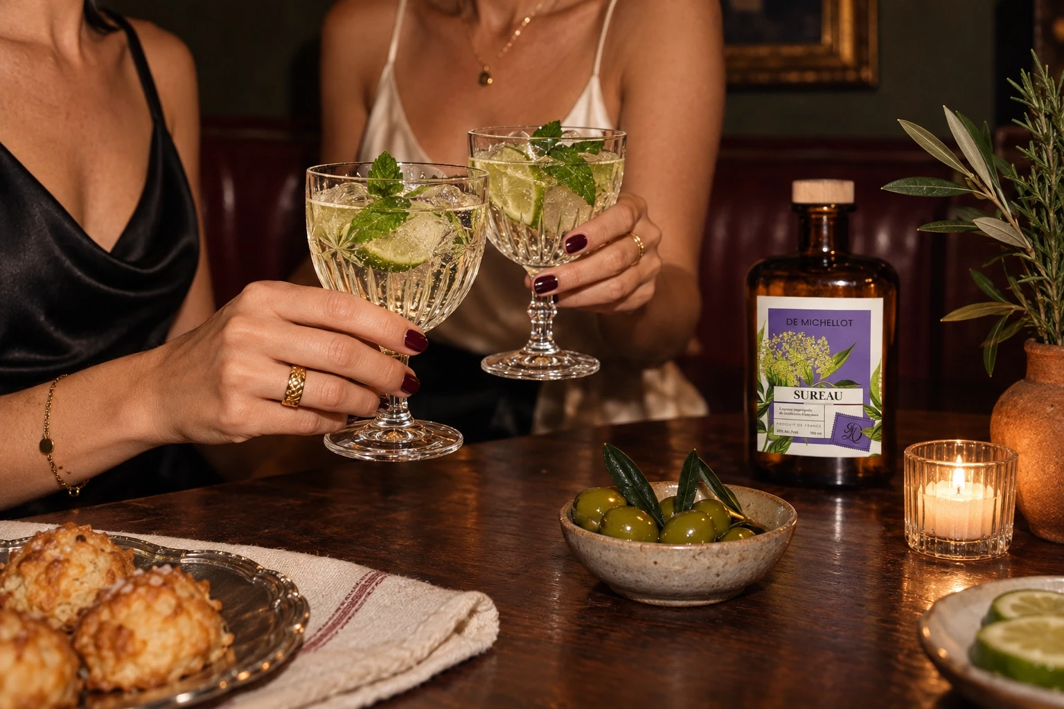 Sureau De Michellot en retrait sur une table de bistrot, deux femmes adultes cadrées sans visage tiennent dans leurs mains des Hugo Spritz en verres vintage de cristal taillé, ambiance sombre éclairée au flash et grain fin — scène générée